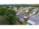 An aerial view showcases the backyard with screened pool, beautiful landscaping, and connecting to a serene residential neighborhood at 1411 Juarez Pl, The Villages, FL 32159