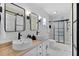 Beautiful bathroom featuring double sinks, black hardware and tiled walk-in shower at 1411 Juarez Pl, The Villages, FL 32159