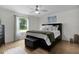Serene bedroom featuring a king-size bed, hardwood floors, and a large window at 1411 Juarez Pl, The Villages, FL 32159