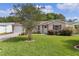 Inviting front exterior features a green lawn, manicured landscaping, and a paved driveway at 1411 Juarez Pl, The Villages, FL 32159