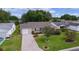Well-manicured front yard with a brick driveway, lush green grass, and tasteful landscaping around the charming single-story home at 1411 Juarez Pl, The Villages, FL 32159