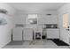 Bright laundry room features modern washer and dryer, ample cabinet storage, and convenient utility sink at 1411 Juarez Pl, The Villages, FL 32159
