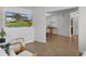 Open living room with wood floors, featuring a TV and a view into the adjacent dining area at 1411 Juarez Pl, The Villages, FL 32159