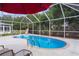 Screened-in pool area with in-ground pool and patio furniture at 1411 Juarez Pl, The Villages, FL 32159