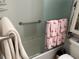 Bathroom showcasing shower/tub combo with grab bar and flamingo themed decorative towels at 1618 Juno Trail, Astor, FL 32102