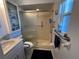 Bathroom featuring walk in shower with safety bars, blue accent cabinet, commode and modern sink basin at 1618 Juno Trail, Astor, FL 32102