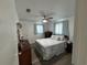 Cozy bedroom with a ceiling fan, plush bed with decorative pillows, and curtains to filter light at 1618 Juno Trail, Astor, FL 32102