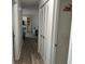 Hallway leading to the living room showcasing neutral decor, wood laminate flooring and white accent doors at 1618 Juno Trail, Astor, FL 32102
