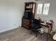 This office space features wood laminate floors, a wooden desk and shelving unit and a window for great natural lighting at 1618 Juno Trail, Astor, FL 32102