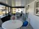 Relax on the screened porch with wicker furniture, a dining table and chairs, and views of the lush landscape at 1618 Juno Trail, Astor, FL 32102