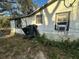 Shows a weathered home exterior needing repairs with overgrown bushes and old windows at 2217 Azalea Ct, Lakeland, FL 33815