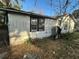 Shows weathered home exterior needing repairs with overgrown bushes and old windows at 2217 Azalea Ct, Lakeland, FL 33815