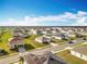 Wide aerial image of a suburban neighborhood with well-kept lawns and neatly arranged streets at 2369 Crossandra St, Mascotte, FL 34753