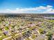 Extensive aerial view of a residential neighborhood bordering a tranquil lake under a partly cloudy blue sky at 2369 Crossandra St, Mascotte, FL 34753