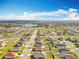 Aerial view of a community surrounded by greenery, featuring modern homes, tidy lawns, and a water tower at 2369 Crossandra St, Mascotte, FL 34753