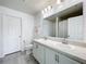 Spacious bathroom featuring double sinks, clean white cabinets, and a large mirror, offering ample counter space at 2369 Crossandra St, Mascotte, FL 34753