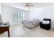 Bright bedroom featuring light wood floors, large window, and a comfortable bed, creating a serene and inviting atmosphere at 2369 Crossandra St, Mascotte, FL 34753