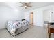 Comfortable bedroom with light wood floors, ceiling fan, and inviting bed, creating a tranquil and relaxing atmosphere at 2369 Crossandra St, Mascotte, FL 34753