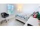 Comfortable bedroom featuring a bed, desk, and a view of the outside at 2369 Crossandra St, Mascotte, FL 34753