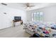 Bright bedroom featuring light wood floors, plantation shutters, and a comfortable bed, creating a serene and inviting space at 2369 Crossandra St, Mascotte, FL 34753