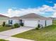 Well-maintained single story home featuring a two-car garage, a neat lawn, and simple landscaping at 2369 Crossandra St, Mascotte, FL 34753