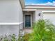 View of the front door with a covered entrance framed with some landscaping at 2369 Crossandra St, Mascotte, FL 34753