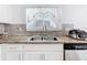 Stainless steel double sinks with granite countertop, stylish backsplash, and modern faucet at 2369 Crossandra St, Mascotte, FL 34753