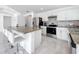 Open concept kitchen features granite island with seating and stainless steel appliances at 2369 Crossandra St, Mascotte, FL 34753