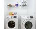 Functional laundry room featuring modern Samsung machines and practical shelving for storage and organization at 2369 Crossandra St, Mascotte, FL 34753