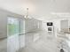 Bright living room with elegant chandeliers, fireplace, and access to the kitchen at 2369 Crossandra St, Mascotte, FL 34753