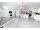 Bright living room with elegant chandeliers, fireplace, and access to the kitchen at 2369 Crossandra St, Mascotte, FL 34753