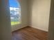 Simple bedroom with wood-look floors and bright window at 2410 Shelby Cir, Kissimmee, FL 34743