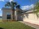 Charming one-story home featuring a well-manicured lawn and a welcoming front entrance with a beautiful palm tree at 2410 Shelby Cir, Kissimmee, FL 34743