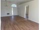Open living room with modern light fixture and wood-look floors at 2410 Shelby Cir, Kissimmee, FL 34743