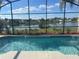 Sparkling pool with a screened enclosure and beautiful lake views beyond at 2410 Shelby Cir, Kissimmee, FL 34743