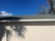 Durable asphalt shingle roof with seamless white gutters against a clear blue sky at 2410 Shelby Cir, Kissimmee, FL 34743