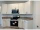 Well-equipped kitchen boasts stainless steel appliances and white cabinetry at 277 Harper Estates Cir, Lake Wales, FL 33859