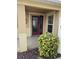 Home's front entry featuring a red door and lush landscaping at 3362 Sebastion Ave, The Villages, FL 32163