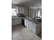 Modern kitchen with white cabinets, granite countertops, and black appliances at 3362 Sebastion Ave, The Villages, FL 32163