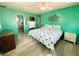 King bed, teal walls, and access to the bathroom at 408 Hawthorne Blvd, Leesburg, FL 34748