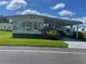Single-wide manufactured home with carport and well-manicured lawn at 408 Hawthorne Blvd, Leesburg, FL 34748