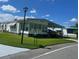 Landscaped manufactured home with a covered carport and street view at 408 Hawthorne Blvd, Leesburg, FL 34748