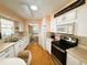 White kitchen cabinets, stainless steel appliances, and wood-look flooring at 408 Hawthorne Blvd, Leesburg, FL 34748