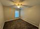 Well-lit bedroom with carpeted floor, neutral walls, and a ceiling fan at 412 Avenue M Ne, Winter Haven, FL 33881