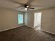 Cozy bedroom with a ceiling fan, plush carpeting, and a view into the bathroom at 412 Avenue M Ne, Winter Haven, FL 33881