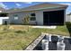 Backyard featuring a covered patio, green grass, and a garden area with young trees at 414 Taft Dr, Davenport, FL 33837