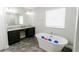 A luxurious bathroom with double sinks, granite countertop, and a soaking tub at 414 Taft Dr, Davenport, FL 33837