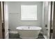 A modern bathroom featuring a soaking tub and a large window at 414 Taft Dr, Davenport, FL 33837
