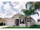 Charming single-story home with stone accents, lush lawn, and beautiful palm trees at 414 Taft Dr, Davenport, FL 33837