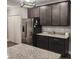 Modern kitchen with dark wood cabinets, granite countertops, stainless steel appliances, and large island at 414 Taft Dr, Davenport, FL 33837
